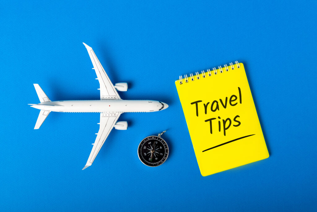 Travel Tips - notepad, compass and toy airplane on blue background. Darwin Visitor Guide