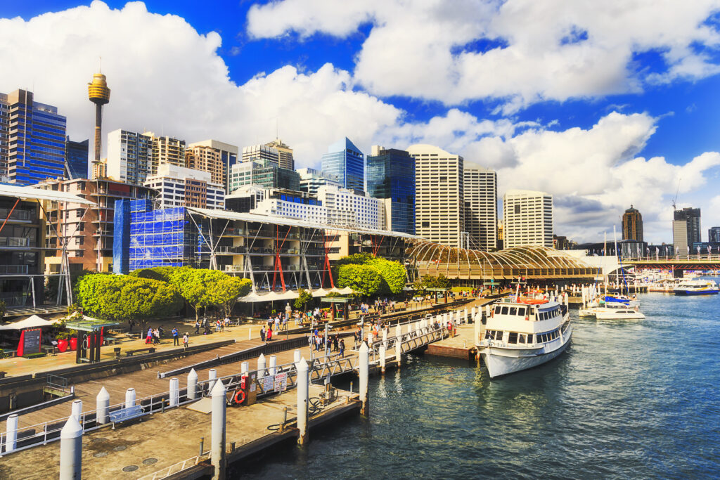 Sydney Darling Harbour Kings wharf with docked ship along the pier with modern architecture towers and skyscrapers on a sunny summer day.