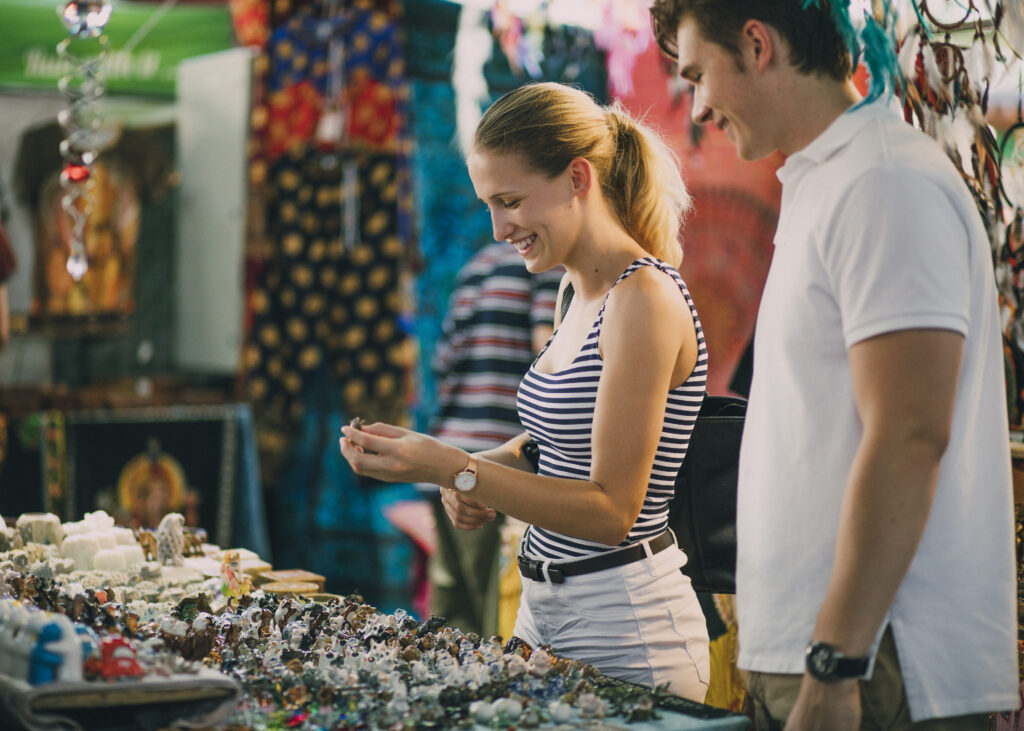 Planning a Trip to Melbourne. Young couple are looking at a jewellery stall in Queen Victoria Market, Australia.