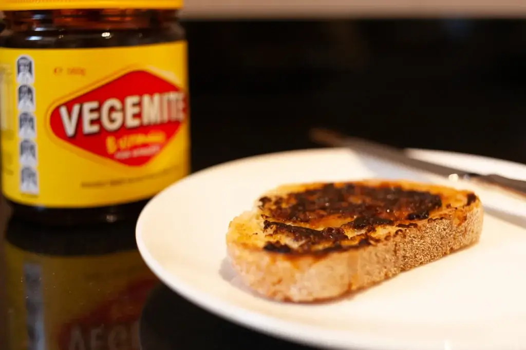 Vegemite and butter on sough dough toast, knife and Vegemite jar. An classic icon. Vegemite, an Australian iconic taste sensation.