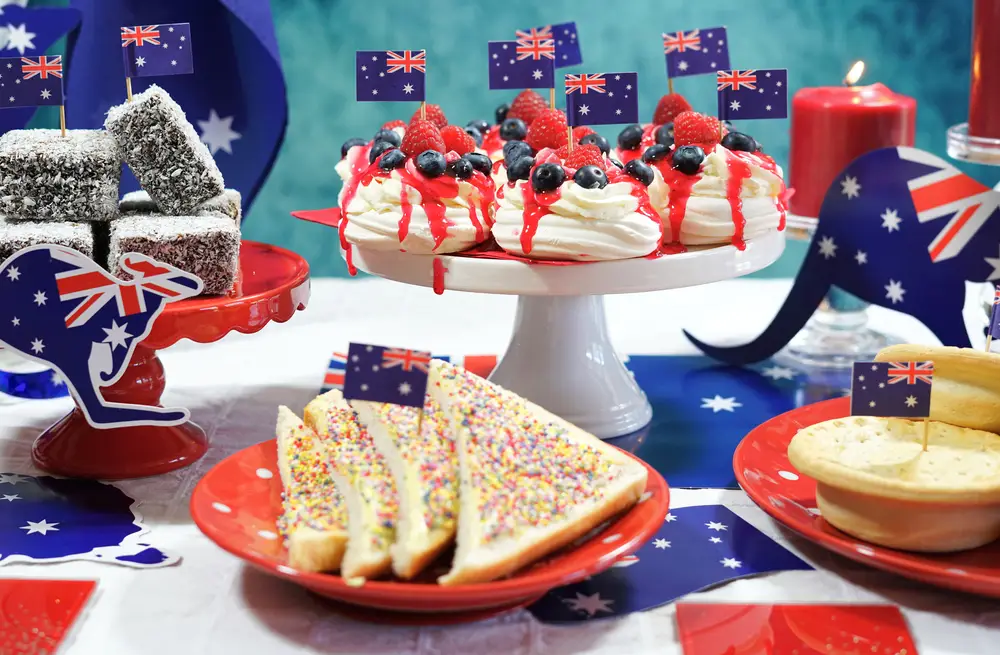 central coast. Australian theme party table with flags and iconic food including mini pavlovas, lamingtons, meat pies and fairy bread.