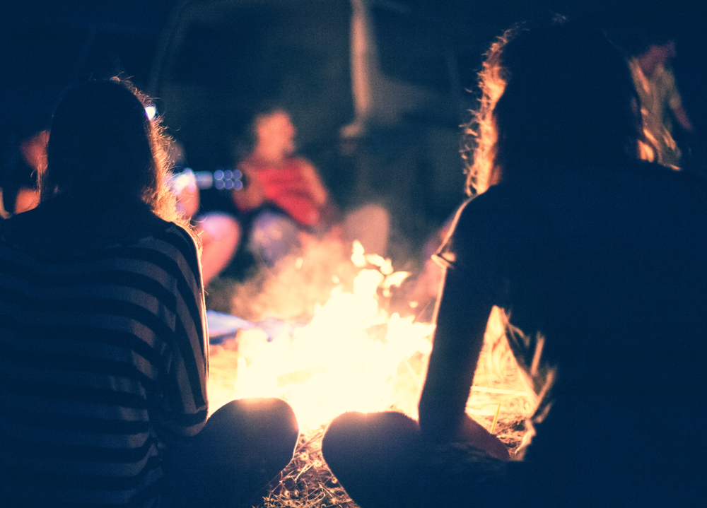 Abiut us. People sit at night round a bright bonfire. Story telling.