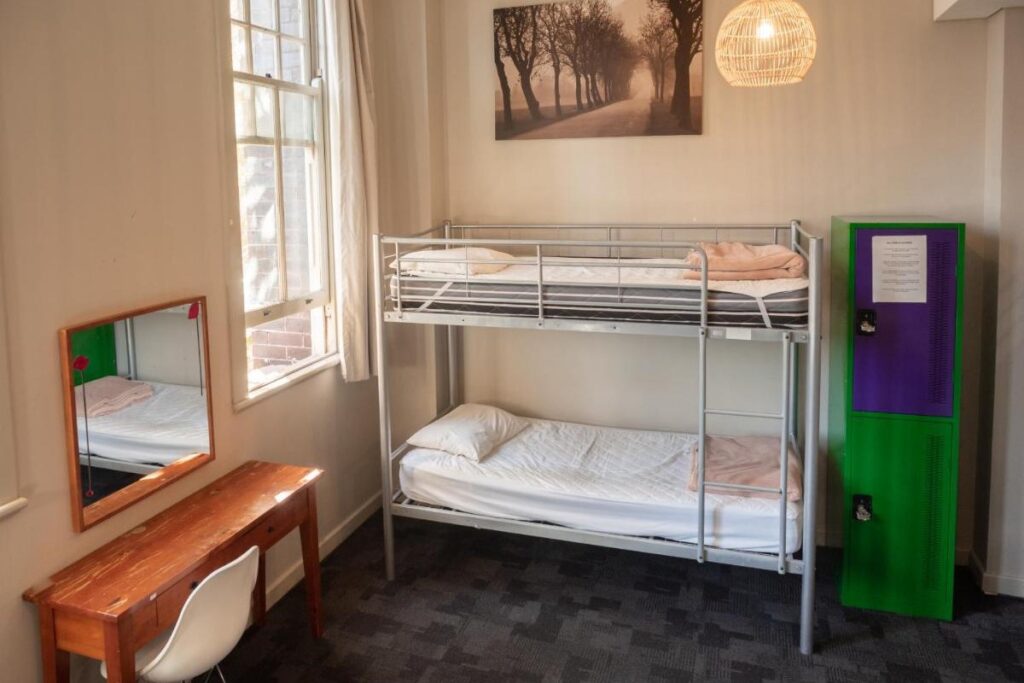 Mixed dormitory with a bunk bed and a large sunny window for thravellers to rest at Big Backpackers Hostel 