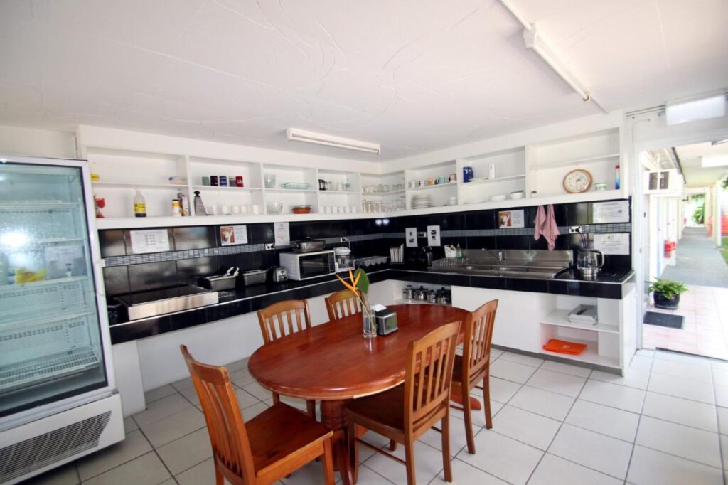 A fully equipped kitched with wodden dining table at Cstay Guest House on Magnetic Island