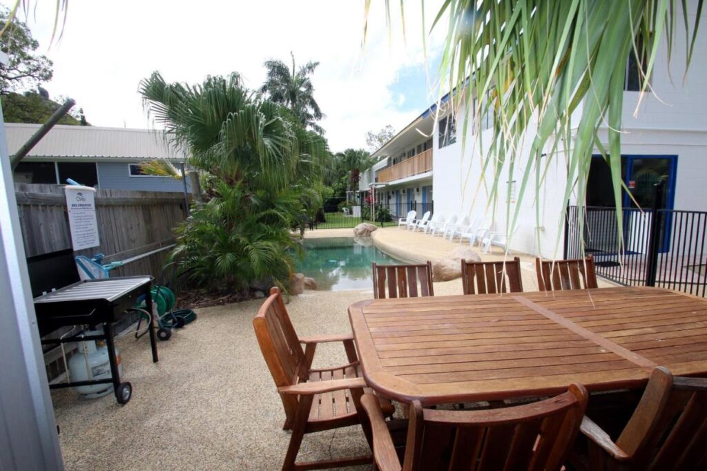 Shared BBQ area with deckchairs and swimming pool for outdoor guest entertainment at Cstay Guest House on Magnetic Island