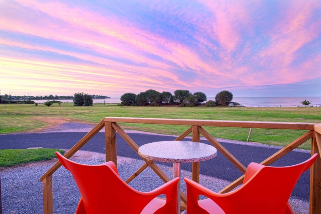 Picturesque views o fgreen grass ocean and spectacular sky from your cabin at Discovery Parks Devonport.