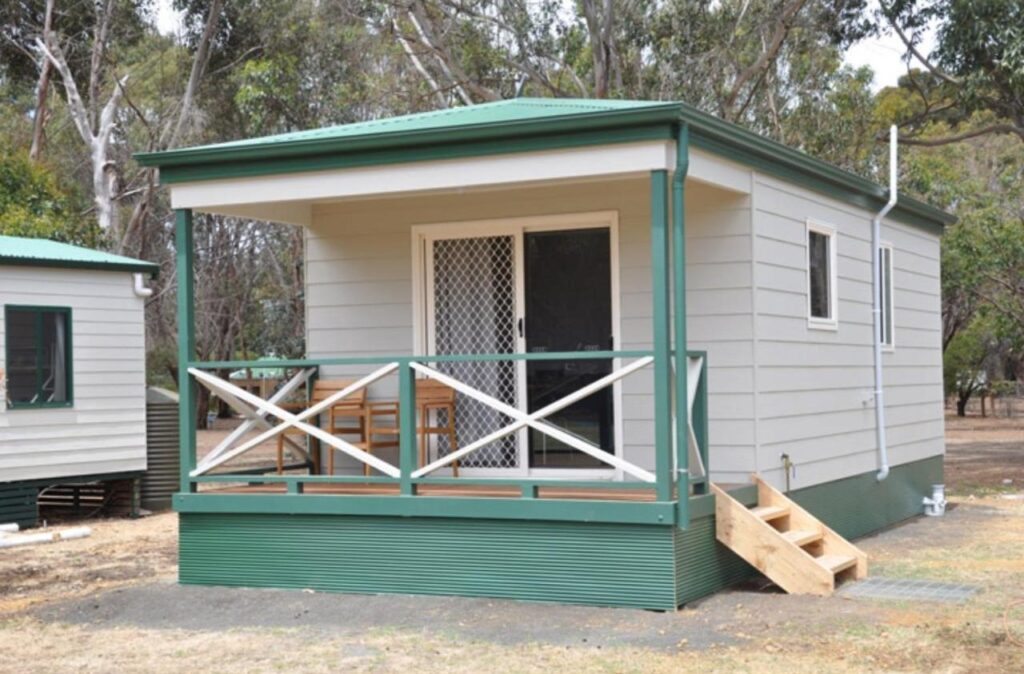 One of the cabins in white with green deck rails at Discovery Parks Kangaroo Island 