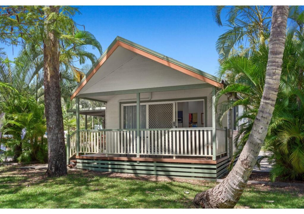 A tropical cabin surrounded by palm trees at Discovery Parks Tannum Sands