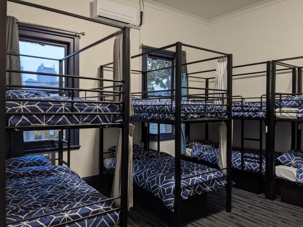 A six bed dormitort with bunk beds and fresh clean sheets for your stay in Melbourne at Queen Victoria Hostel