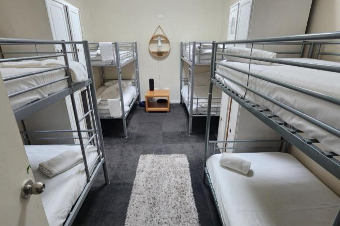 A mixed dormitory for guests and travellers to rest with clean sheets and towels at The Entrance Backpackers