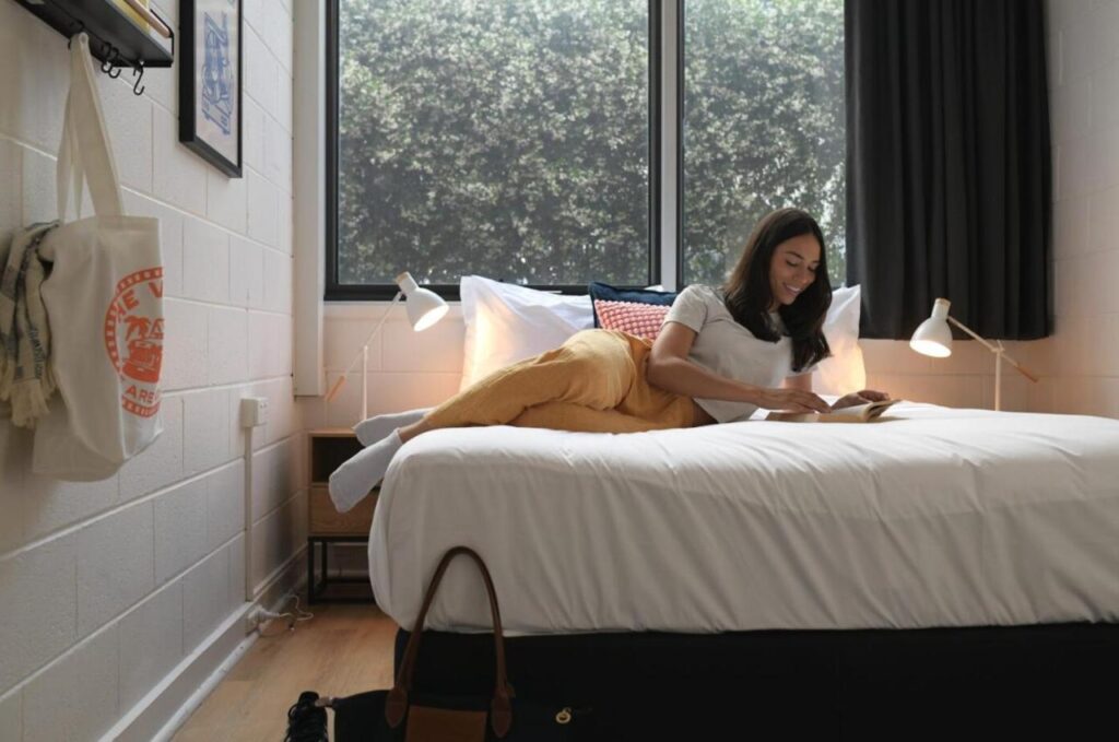 Young traveller reading a book in a private room at The Village Glebe