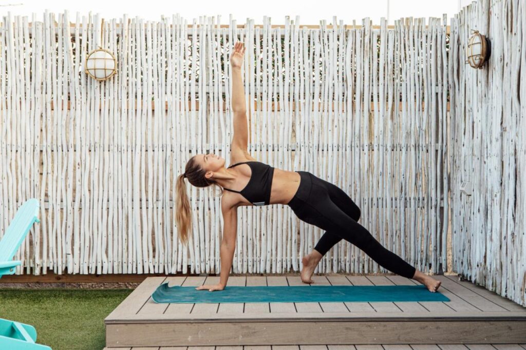 A womain rising up to a start to her day doing a Yoga class at Wake Up! Bondi Beach