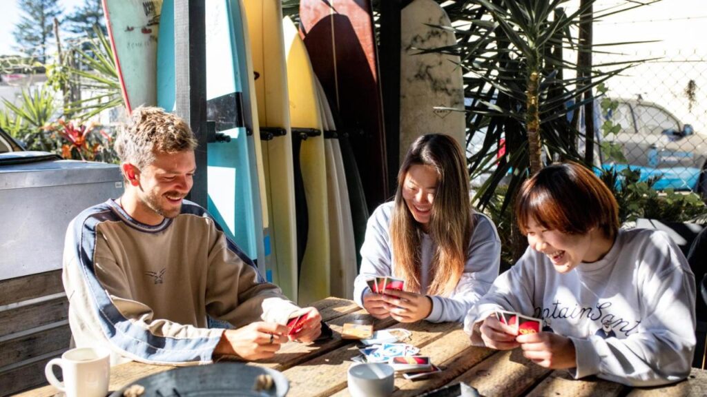 Travellers and guests playing UNO in the outdoor terrace at Woopi Backpackers