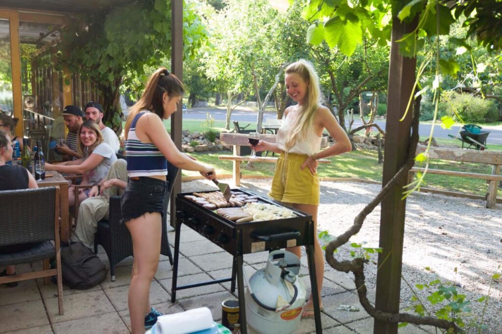 Travellers cooking during a social BBQ event at the YHA Grampians Eco Halls Gap 
