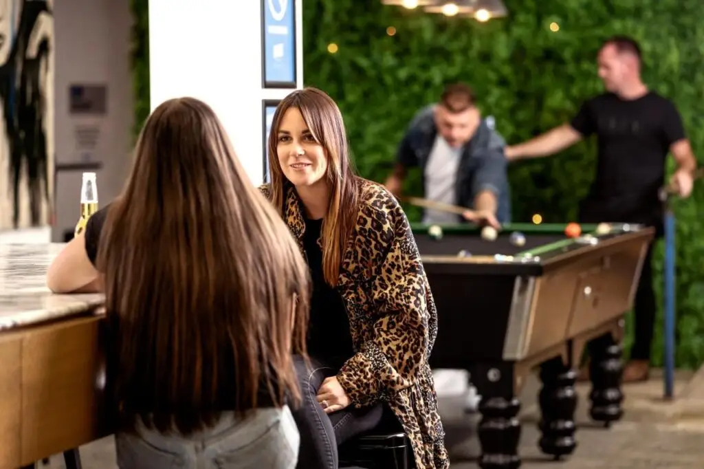 Travellers socialising in the bar and games area at Bayside House