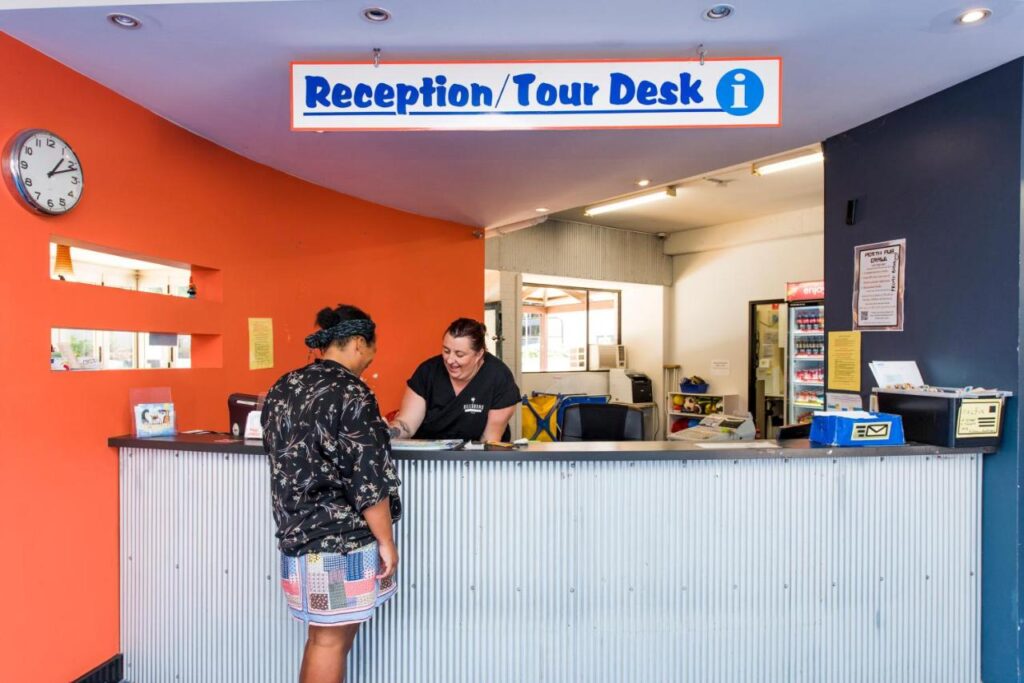 Friendly receptionist staff assisting a traveller to check in at Billabong Backpackers Resort