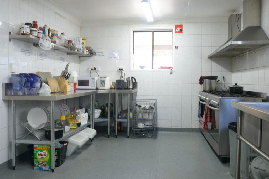 A shared kitchen area with stainless steel bench tops, stove and oven and lots of utensils to use at Gonow Family Backpackers Hostel