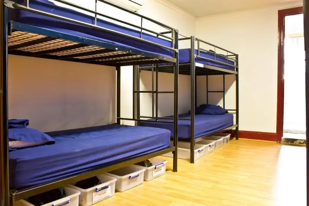 A dormitory with two bunk , four single beds with blue sheets at Mad Monkey Kings Cross