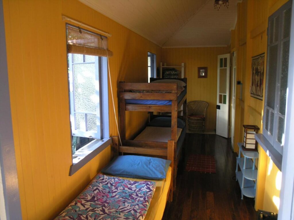 A three bed dormitory with a bunk bed and a single bed at Mango Tourist Hostel