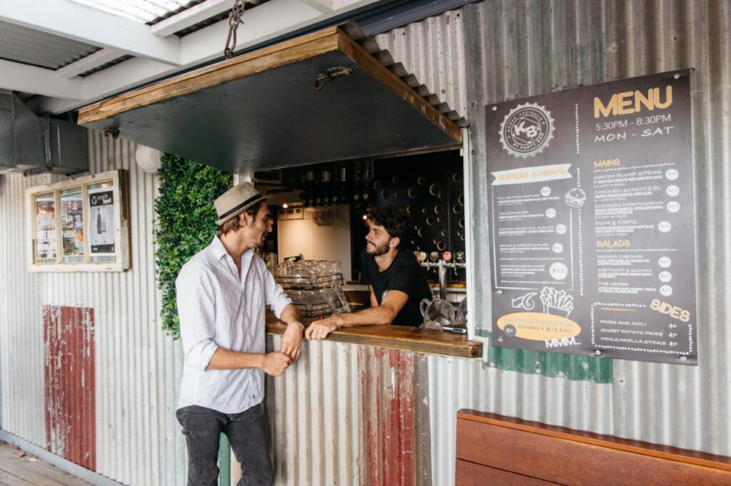 The bar and restaurant with a traveller ordering a fresh cold beer at Nomads Noosa