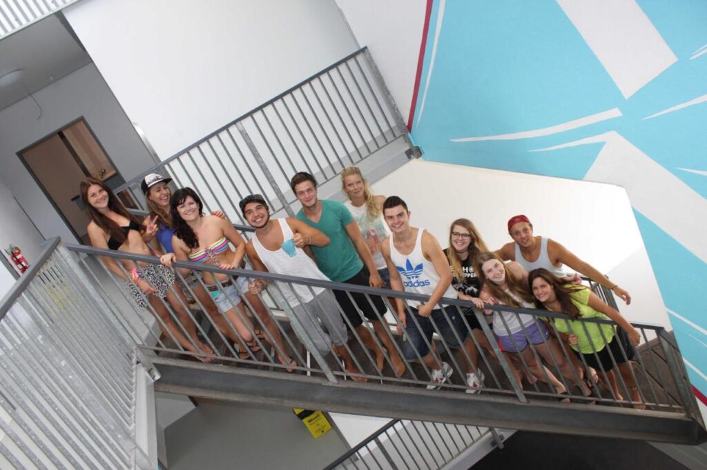 A bunch of friendly travellers on the steps posing for a photo at Port Douglas Backpackers