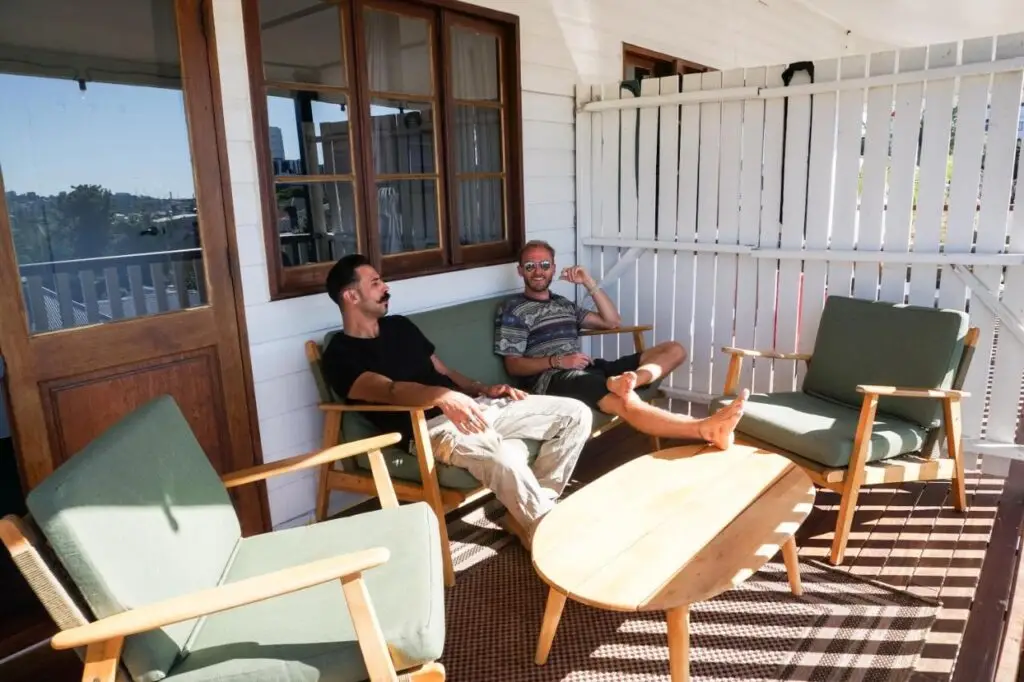 Two travellers chatting on the verandah at Somewhere To Stay Backpackers