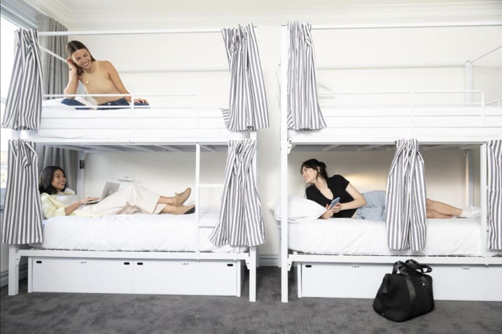 A female only dormitory with a few travellers relaxing in bed at The Pacific House