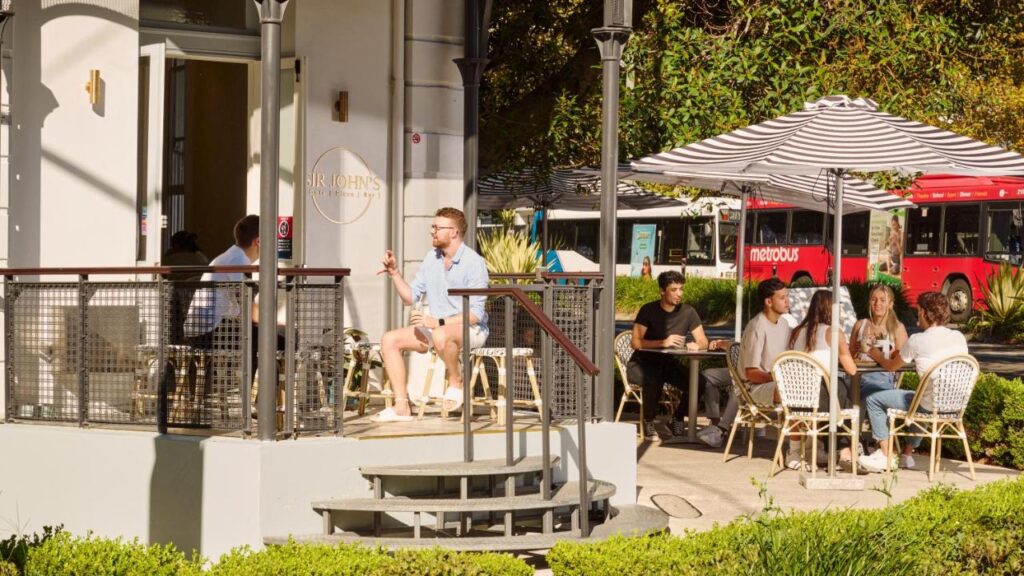 Cafe and outdoor space with people sitting and tables and chairs at the The Pacific House