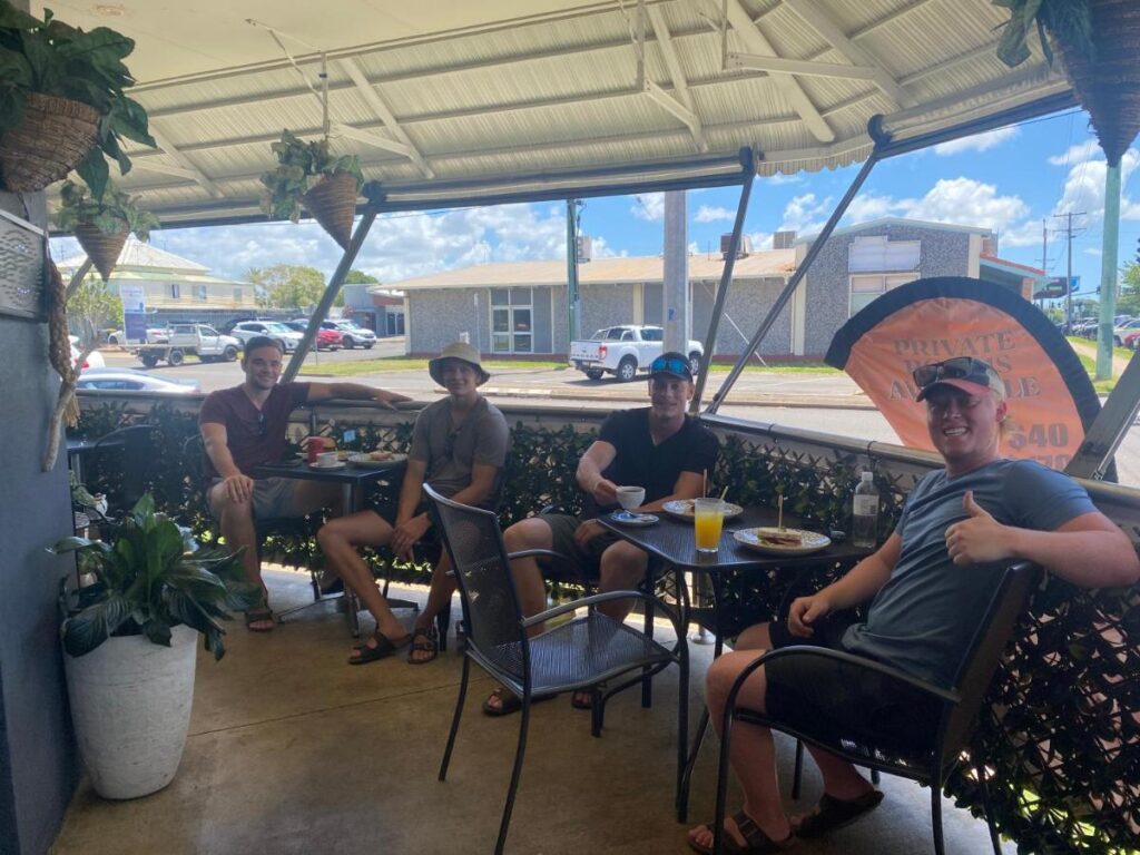 A few travellers relaxing and havin glinch under the verandah at Tomato Backpackers