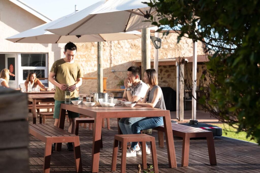 Guests socialising in the outdoor spaces at YHA Port Elliot Beach House