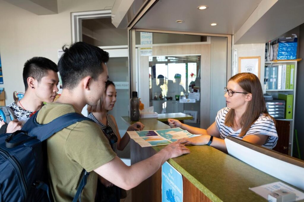 Traveller guests being greeted by friendly reception staff at YHA Port Elliot Beach House